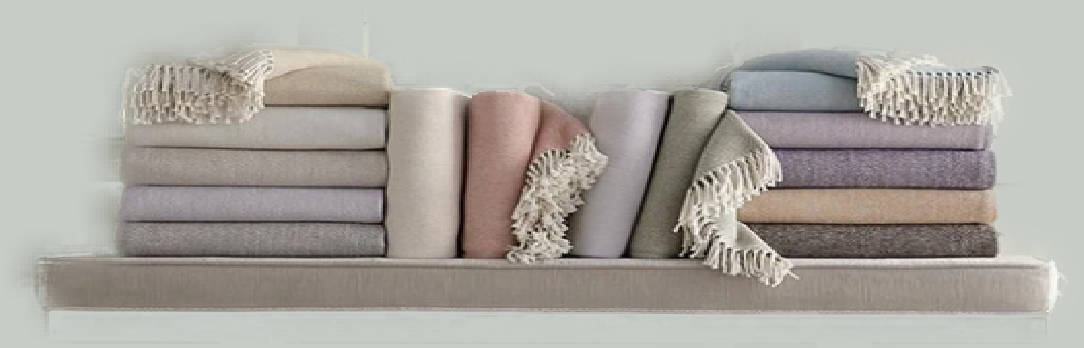 Luxury pastel colored throw blankets stacked on a shelf