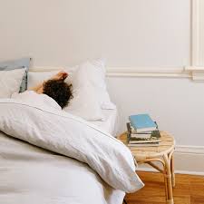 Person sleeping in bed with Coyuchi bedding.