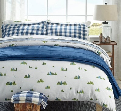 Blue, white, green various patterned flannel L.L. Bean sheets on a bed.