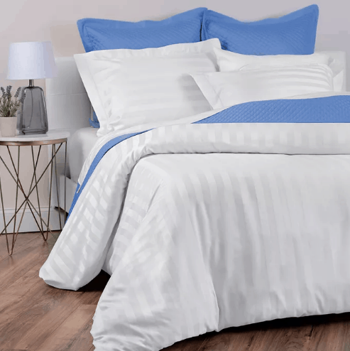 Blue and white pillows and bedding on a bed.