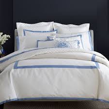 Elegant white bedding on bed with blue detailing.