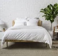 Modern looking white sheets on a bed.