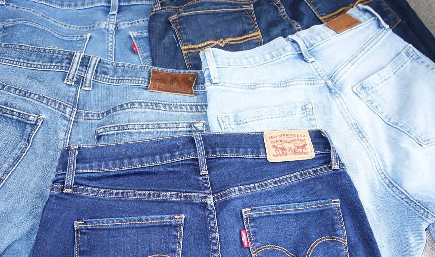 A few different pairs of jeans with back pockets showing